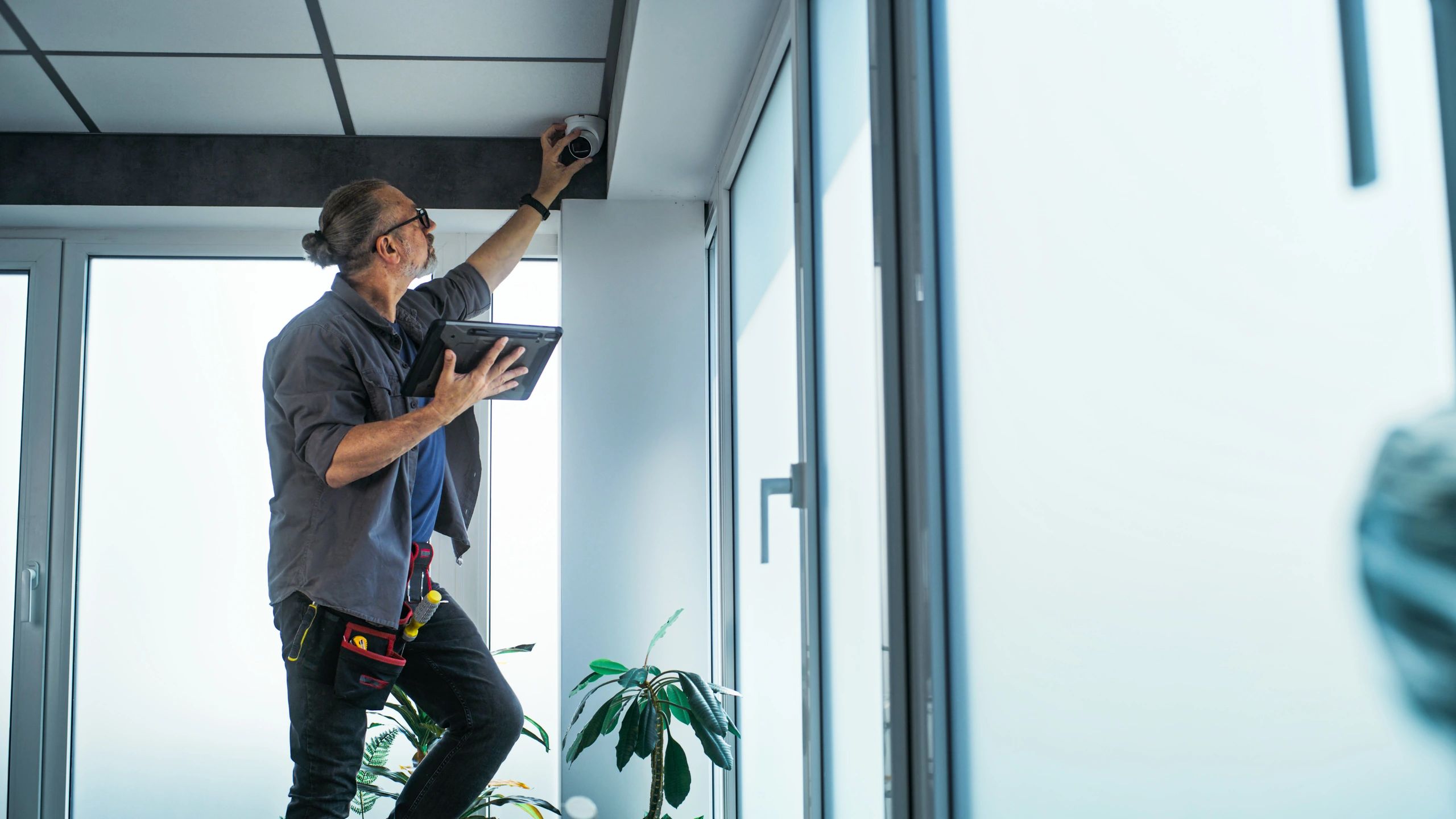 Technician installing a CCTV camera in an office